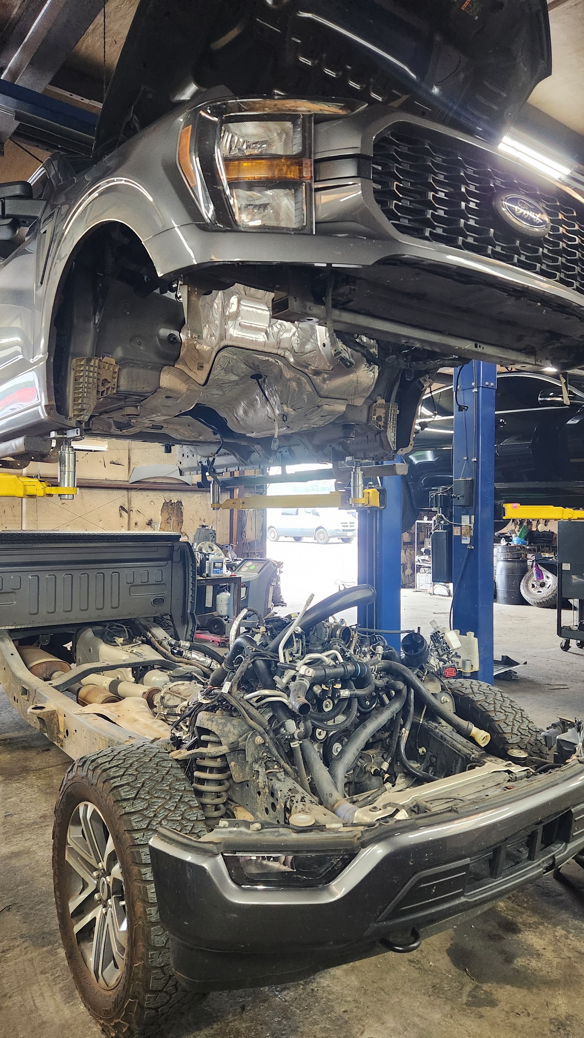 A Ford F-150 on the lift with its engine out